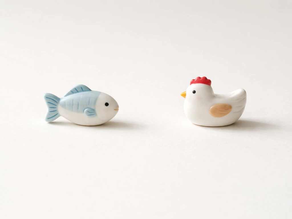 Minimal desk scene with two small food icons—fish and chicken/bird—side by side under soft daylight.